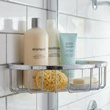 Shower caddy with shampoo, conditioner, and body wash on a tiled shower wall.